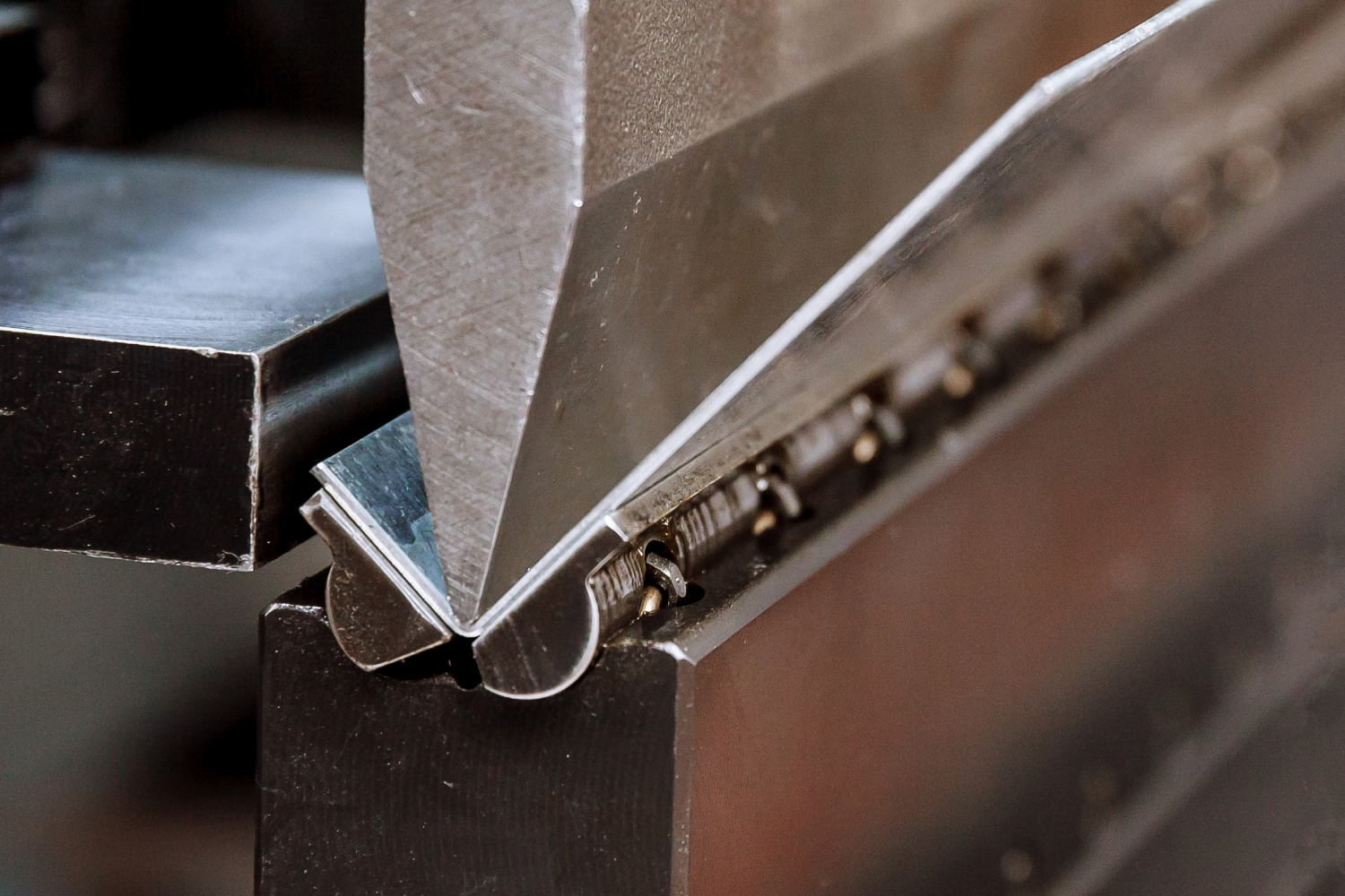 A sophisticated machine precisely bending and shaping steel, illustrating Dakota Steel and Trim, Inc.'s advanced technology and skilled craftsmanship in slitting, bending, and rollforming.